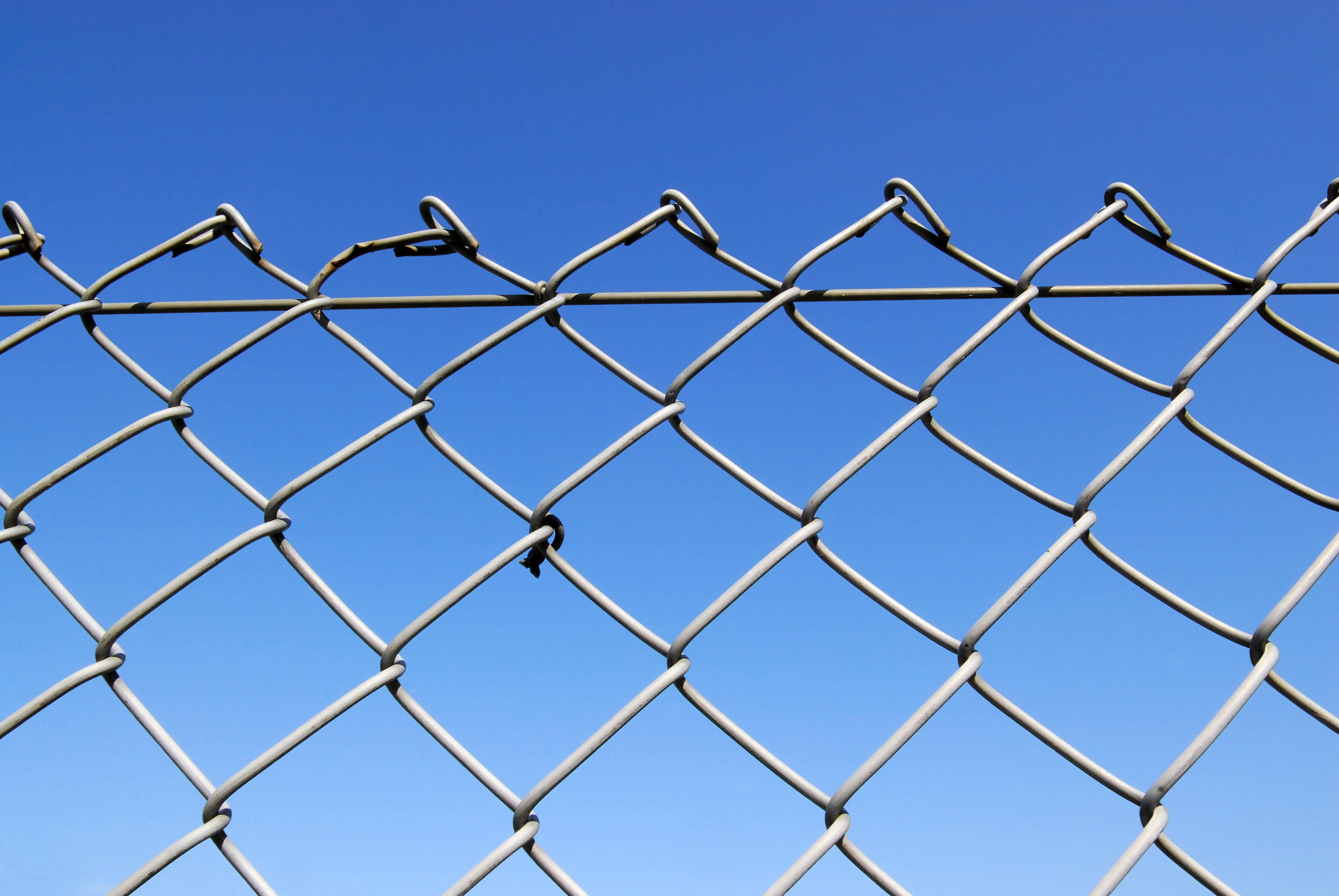 Chain link fence with blue sky background